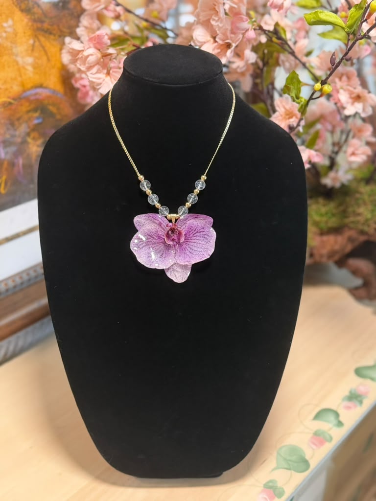 Natural orchid encapsulated in resin, paired with a 14K gold-plated necklace featuring crystal beads.